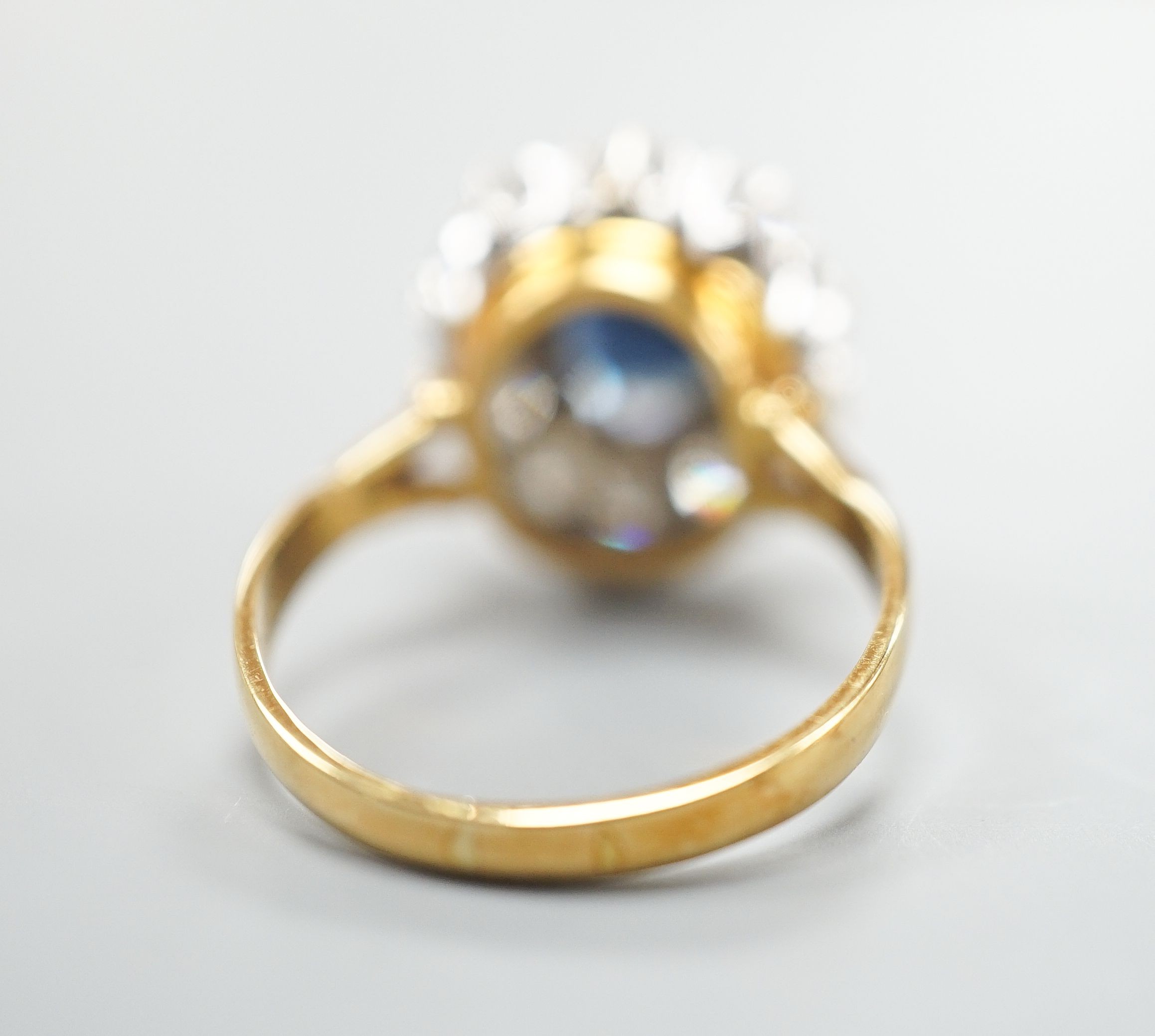 A modern 18ct gold, sapphire and diamond set oval cluster ring, size P/Q, gross weight 6.2 grams.